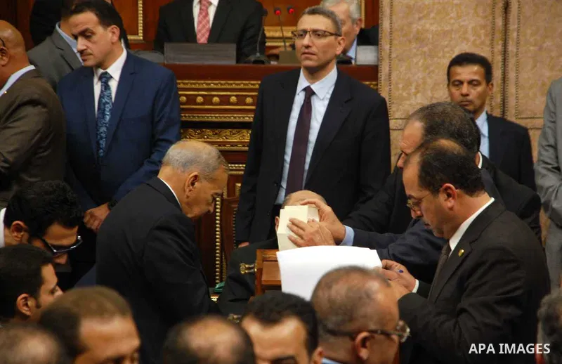 Officials count ballots inspect boxes containing ballot for new President of the Egyptian Council of Representatives during the inaugural session, the first to convene in three years, in Cairo, Egypt, Sunday, Jan. 10, 20...