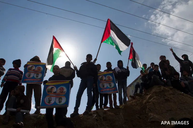 Relatives of four Palestinian men abducted by unidentified masked gunmen on August 19, hold their relatives' pictures during a protest demanding for their return, in front of the Gaza-Egypt border in Rafah in the souther...