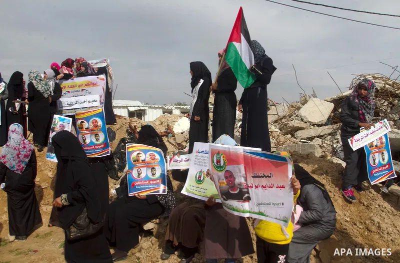 Relatives of four Palestinian men abducted by unidentified masked gunmen on August 19, hold their relatives' pictures during a protest demanding for their return, in front of the Gaza-Egypt border in Rafah in the souther...