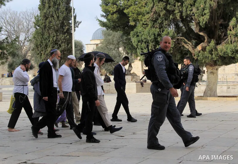 Jewish settlers walk protected by Israeli security forces near Jerusalem's Dome of the Rock mosque in the Al-Aqsa mosque compound on Jan. 11, 2016. Photo by Mahfouz Abu Turk