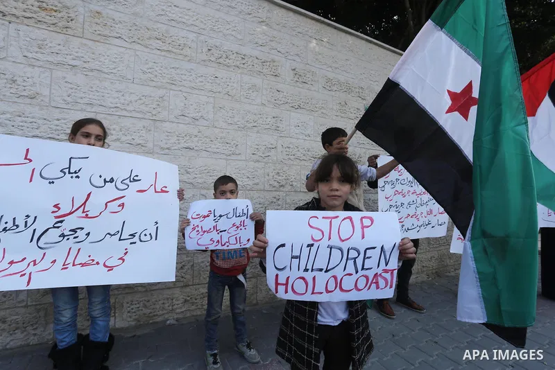 Palestinians hold banners during a protest to show solidarity with the Syrians of Madaya on hunger caused by the siege, in front of Red cross office, in Gaza city on January 12, 2016. Photo by Mohammed Asad