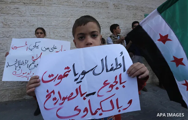 Palestinians hold banners during a protest to show solidarity with the Syrians of Madaya on hunger caused by the siege, in front of Red cross office, in Gaza city on January 12, 2016. Photo by Mohammed Asad