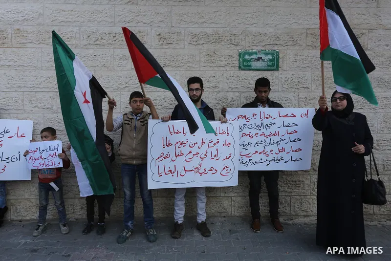 Palestinians hold banners during a protest to show solidarity with the Syrians of Madaya on hunger caused by the siege, in front of Red cross office, in Gaza city on January 12, 2016. Photo by Mohammed Asad
