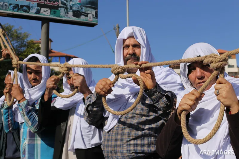 Palestinian families of martyrs, hold banners during a protest to demand their salaries, in front of the headquarters of the Council of Ministers, in Gaza City on January 12, 2016. Photo by Mohammed Asad