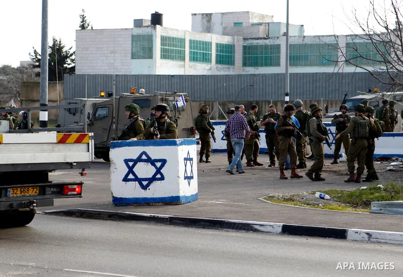 Israeli soldiers stand guard near the scene where two Palestinian men were shot dead by Israeli troops at the Beit Ainun junction northeast of Hebron in the occupied West Bank on Jan. 12, 2016. An Israeli army spokespers...