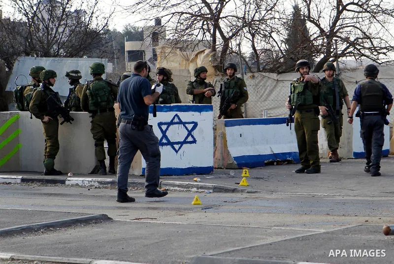 Israeli soldiers stand guard near the scene where two Palestinian men were shot dead by Israeli troops at the Beit Ainun junction northeast of Hebron in the occupied West Bank on Jan. 12, 2016. An Israeli army spokespers...