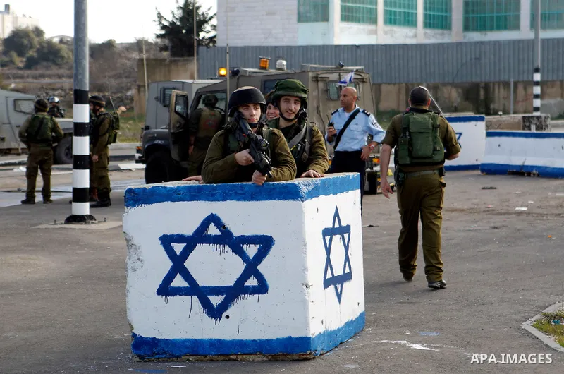Israeli soldiers stand guard near the scene where two Palestinian men were shot dead by Israeli troops at the Beit Ainun junction northeast of Hebron in the occupied West Bank on Jan. 12, 2016. An Israeli army spokespers...