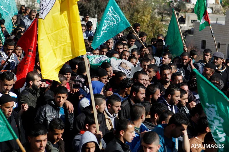 Mourners carry the body of Palestinian Mohammad Kawazbeh, who Israeli military said was shot dead by Israeli soldiers after he tried to stab a soldier on Tuesday, during his funeral in the West Bank village of Sae'er nea...