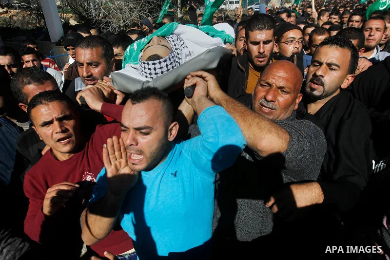 Mourners carry the body of Palestinian Mohammad Kawazbeh, who Israeli military said was shot dead by Israeli soldiers after he tried to stab a soldier on Tuesday, during his funeral in the West Bank village of Sae'er nea...