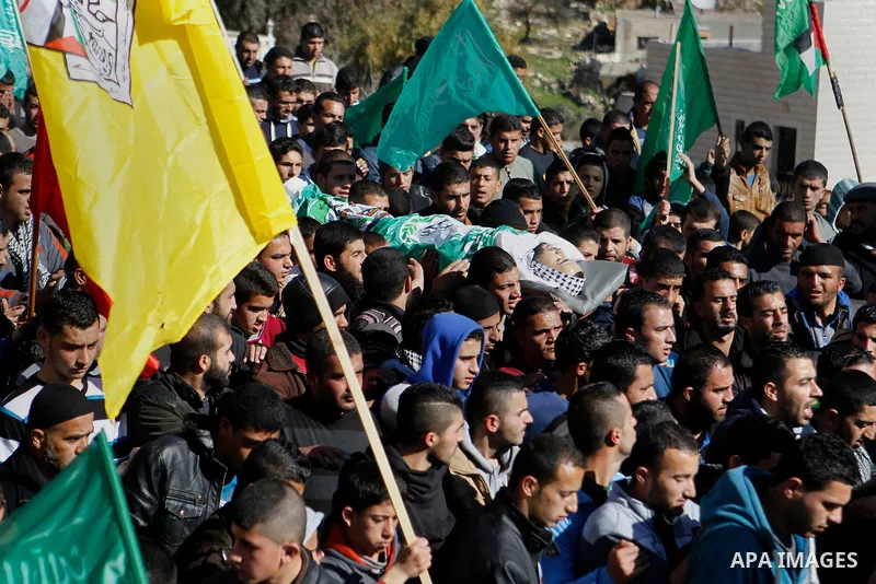 Mourners carry the body of Palestinian Mohammad Kawazbeh, who Israeli military said was shot dead by Israeli soldiers after he tried to stab a soldier on Tuesday, during his funeral in the West Bank village of Sae'er nea...