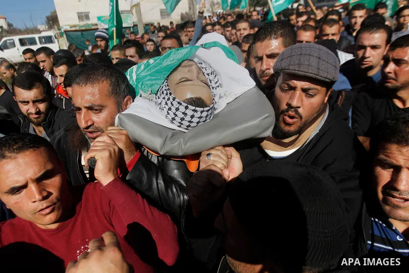 Mourners carry the body of Palestinian Mohammad Kawazbeh, who Israeli military said was shot dead by Israeli soldiers after he tried to stab a soldier on Tuesday, during his funeral in the West Bank village of Sae'er nea...