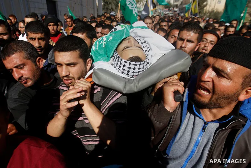 Mourners carry the body of Palestinian Mohammad Kawazbeh, who Israeli military said was shot dead by Israeli soldiers after he tried to stab a soldier on Tuesday, during his funeral in the West Bank village of Sae'er nea...