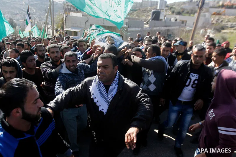 Mourners carry the body of Palestinian Mohammad Kawazbeh, who Israeli military said was shot dead by Israeli soldiers after he tried to stab a soldier on Tuesday, during his funeral in the West Bank village of Sae'er nea...