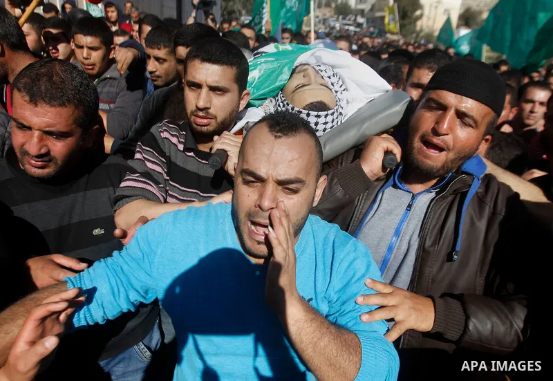 Mourners carry the body of Palestinian Mohammad Kawazbeh, who Israeli military said was shot dead by Israeli soldiers after he tried to stab a soldier on Tuesday, during his funeral in the West Bank village of Sae'er nea...