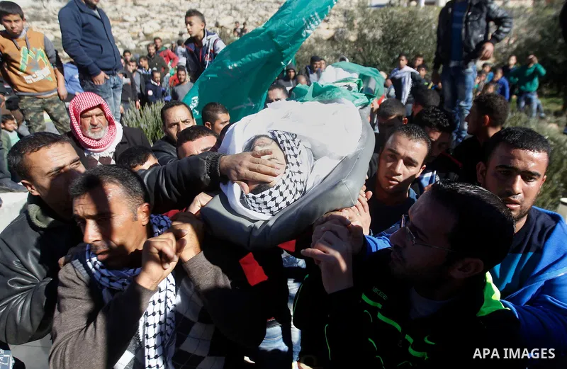 Mourners carry the body of Palestinian Mohammad Kawazbeh, who Israeli military said was shot dead by Israeli soldiers after he tried to stab a soldier on Tuesday, during his funeral in the West Bank village of Sae'er nea...
