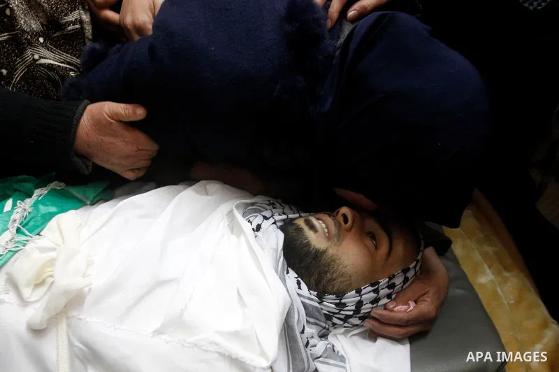 Relatives of Palestinian Mohammad Kawazbeh, who Israeli military said was shot dead by Israeli soldiers after he tried to stab a soldier on Tuesday, mourn during his funeral in the West Bank village of Sae'er near Hebron...