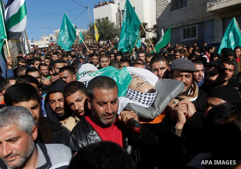 Mourners carry the body of Palestinian Mohammad Kawazbeh, who Israeli military said was shot dead by Israeli soldiers after he tried to stab a soldier on Tuesday, during his funeral in the West Bank village of Sae'er nea...