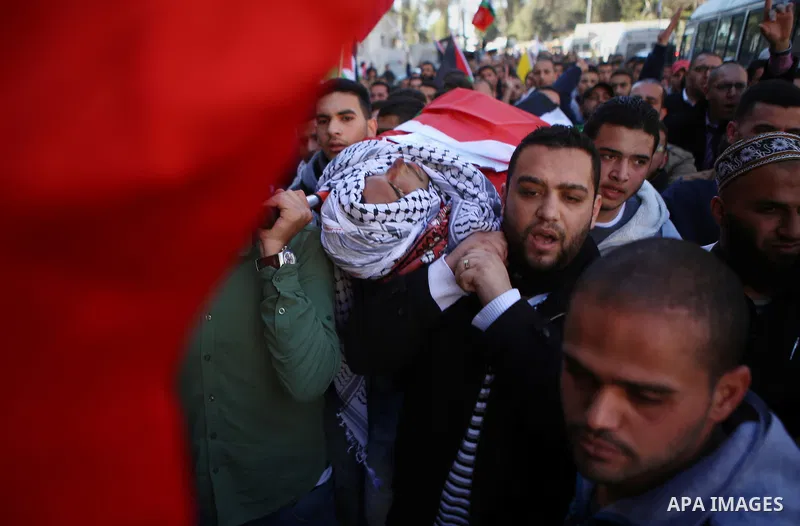 Mourners carry the body of Palestinian Mustafa al-Khatib,17, who Israeli military said was shot dead by Israeli soldiers after he tried to stab a soldier on 12 October, during his funeral in the West Bank city of Ramalla...