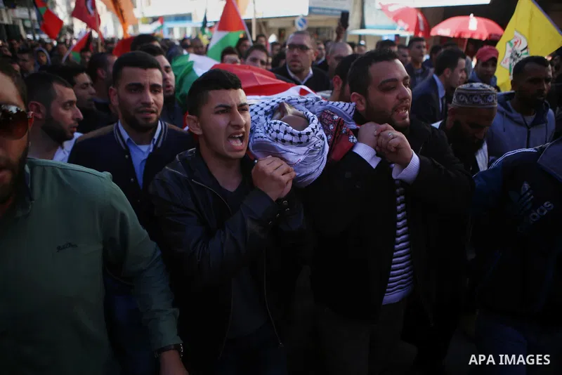 Mourners carry the body of Palestinian Mustafa al-Khatib,17, who Israeli military said was shot dead by Israeli soldiers after he tried to stab a soldier on 12 October, during his funeral in the West Bank city of Ramalla...