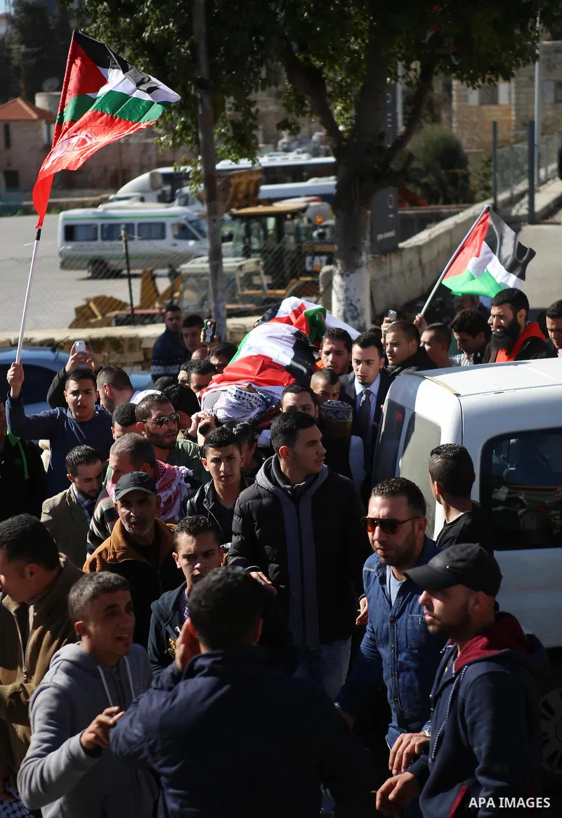 Mourners carry the body of Palestinian Mustafa al-Khatib,17, who Israeli military said was shot dead by Israeli soldiers after he tried to stab a soldier on 12 October, during his funeral in the West Bank city of Ramalla...