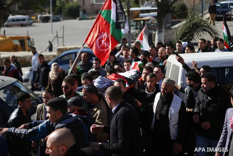 Mourners carry the body of Palestinian Mustafa al-Khatib,17, who Israeli military said was shot dead by Israeli soldiers after he tried to stab a soldier on 12 October, during his funeral in the West Bank city of Ramalla...