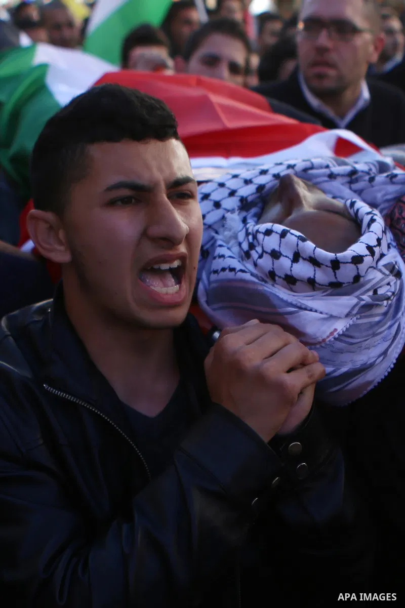 Mourners carry the body of Palestinian Mustafa al-Khatib,17, who Israeli military said was shot dead by Israeli soldiers after he tried to stab a soldier on 12 October, during his funeral in the West Bank city of Ramalla...