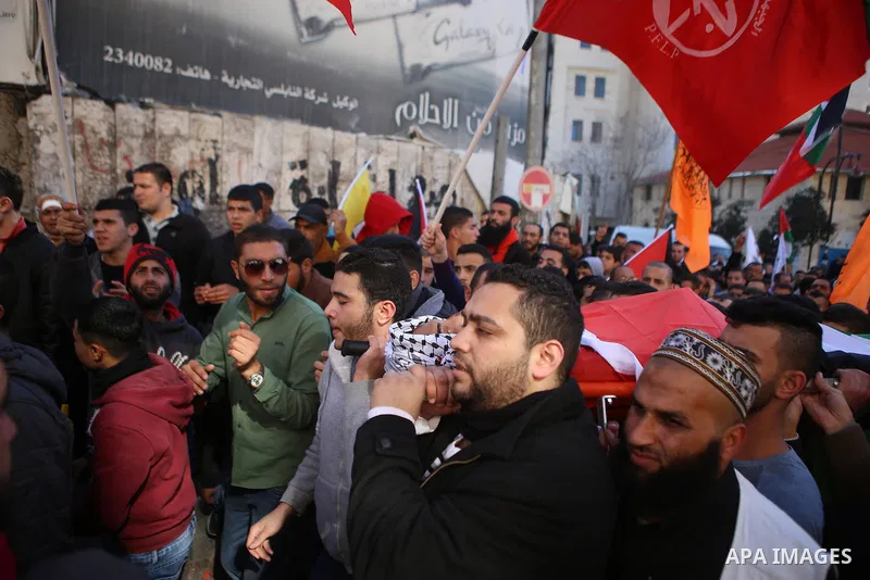 Mourners carry the body of Palestinian Mustafa al-Khatib,17, who Israeli military said was shot dead by Israeli soldiers after he tried to stab a soldier on 12 October, during his funeral in the West Bank city of Ramalla...