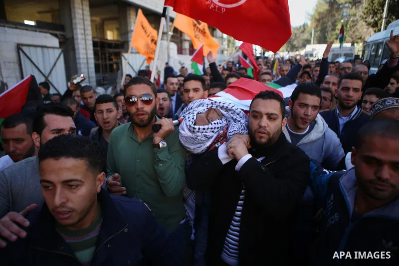 Mourners carry the body of Palestinian Mustafa al-Khatib,17, who Israeli military said was shot dead by Israeli soldiers after he tried to stab a soldier on 12 October, during his funeral in the West Bank city of Ramalla...