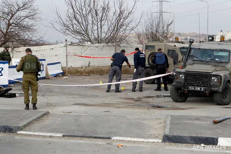 Israeli forensic policemen gather evidence at the site of a stabbing attack at the Beit Ainun junction near Hebron on January 14, 2016. Israeli forces Thursday shot and killed a Palestinian near the Beit Ainun junction n...