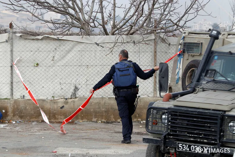 An Israeli forensic policeman gathers evidence at the site of a stabbing attack at the Beit Ainun junction near Hebron on January 14, 2016. Israeli forces Thursday shot and killed a Palestinian near the Beit Ainun juncti...