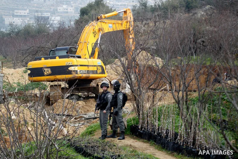 Construction vehicles under the supervision of Israeli forces destroy Palestinian owend house that was built without a permit in the village of Beit Ummar, near the city of Hebron in the Israeli occupied West Bank on Jan...