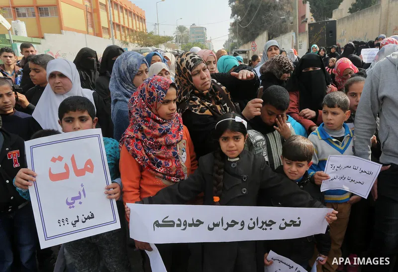 Palestinians hold banners during a protest demanding the Egyptian authorities for the opening of the Rafah crossing in front of the Egyptian embassy, in Gaza city, on January 14, 2016. Photo by Mohammed Asad