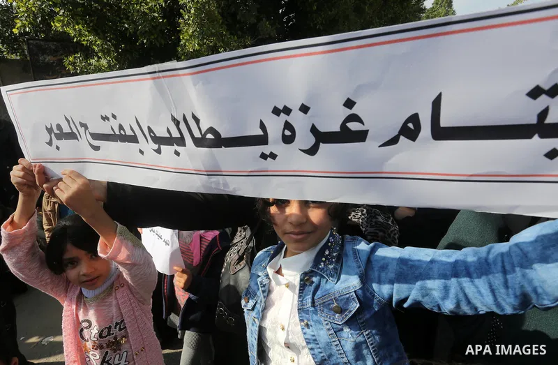 Palestinians hold banners during a protest demanding the Egyptian authorities for the opening of the Rafah crossing in front of the Egyptian embassy, in Gaza city, on January 14, 2016. Photo by Mohammed Asad