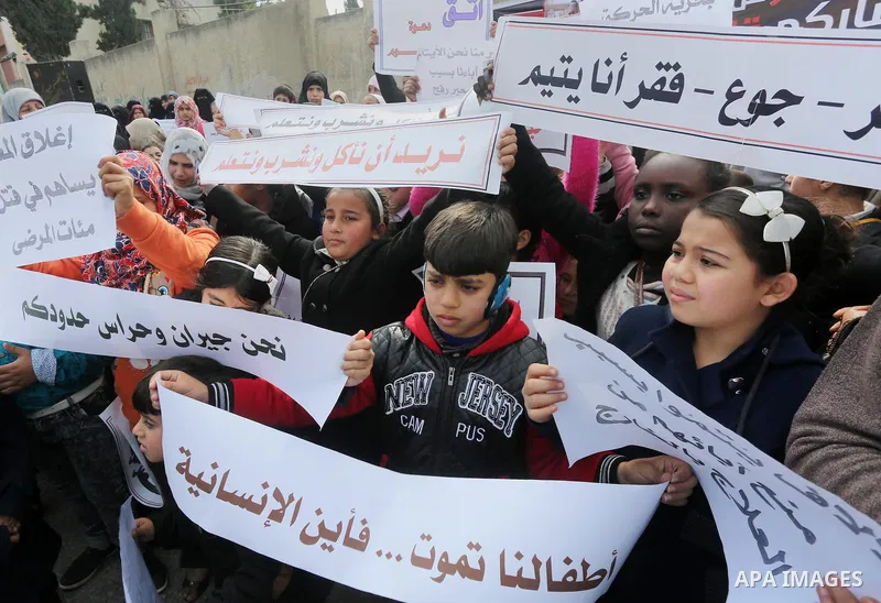 Palestinians hold banners during a protest demanding the Egyptian authorities for the opening of the Rafah crossing in front of the Egyptian embassy, in Gaza city, on January 14, 2016. Photo by Mohammed Asad