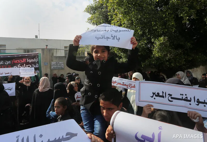 Palestinians hold banners during a protest demanding the Egyptian authorities for the opening of the Rafah crossing in front of the Egyptian embassy, in Gaza city, on January 14, 2016. Photo by Mohammed Asad