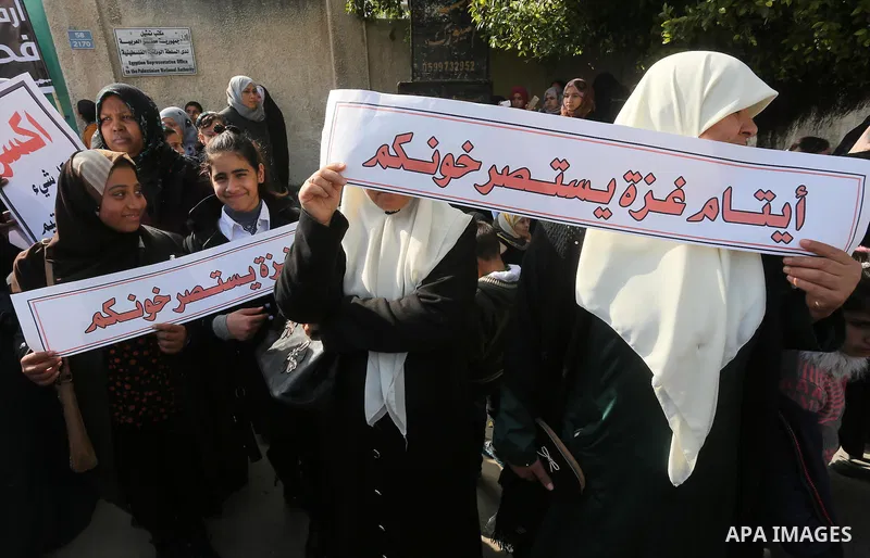 Palestinians hold banners during a protest demanding the Egyptian authorities for the opening of the Rafah crossing in front of the Egyptian embassy, in Gaza city, on January 14, 2016. Photo by Mohammed Asad