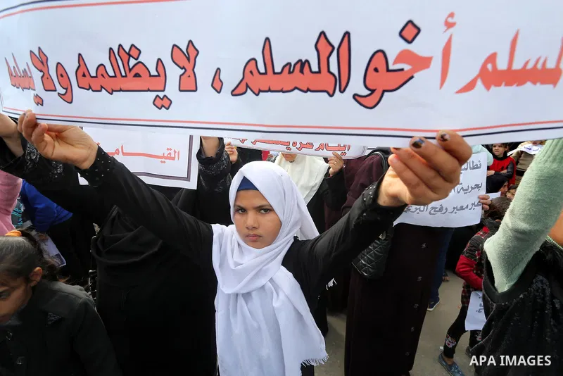 Palestinians hold banners during a protest demanding the Egyptian authorities for the opening of the Rafah crossing in front of the Egyptian embassy, in Gaza city, on January 14, 2016. Photo by Mohammed Asad