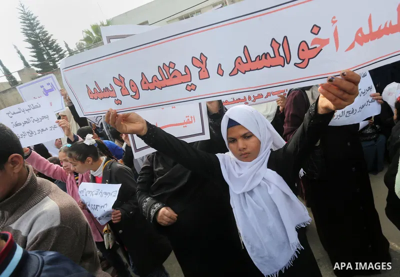 Palestinians hold banners during a protest demanding the Egyptian authorities for the opening of the Rafah crossing in front of the Egyptian embassy, in Gaza city, on January 14, 2016. Photo by Mohammed Asad