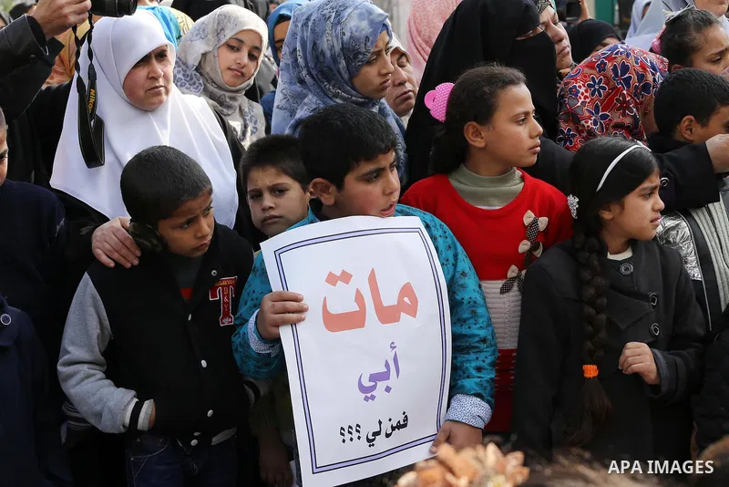 Palestinians hold banners during a protest demanding the Egyptian authorities for the opening of the Rafah crossing in front of the Egyptian embassy, in Gaza city, on January 14, 2016. Photo by Mohammed Asad