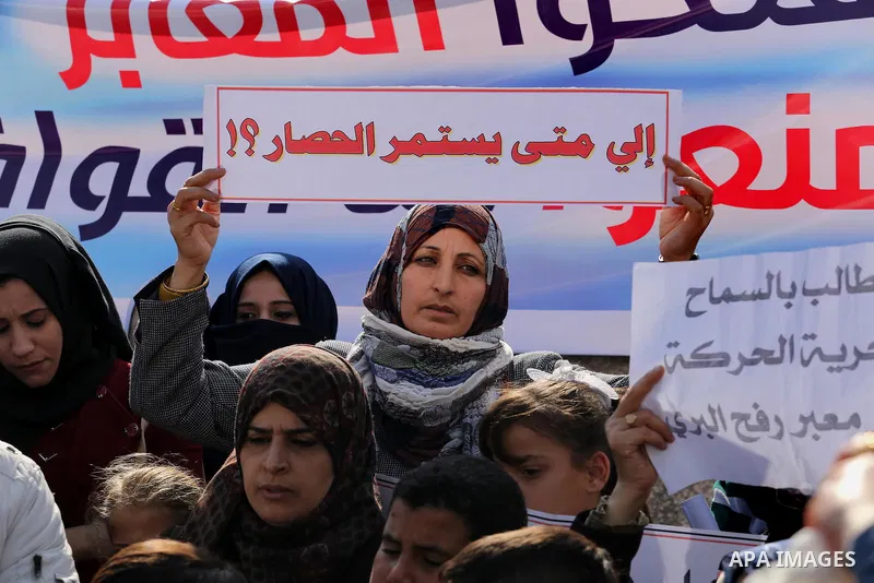 Palestinians hold banners during a protest demanding the Egyptian authorities for the opening of the Rafah crossing in front of the Egyptian embassy, in Gaza city, on January 14, 2016. Photo by Mohammed Asad