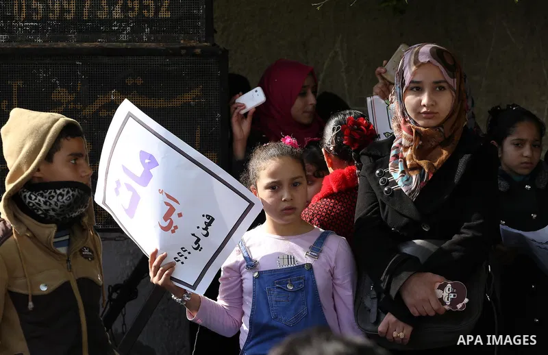 Palestinians hold banners during a protest demanding the Egyptian authorities for the opening of the Rafah crossing in front of the Egyptian embassy, in Gaza city, on January 14, 2016. Photo by Mohammed Asad