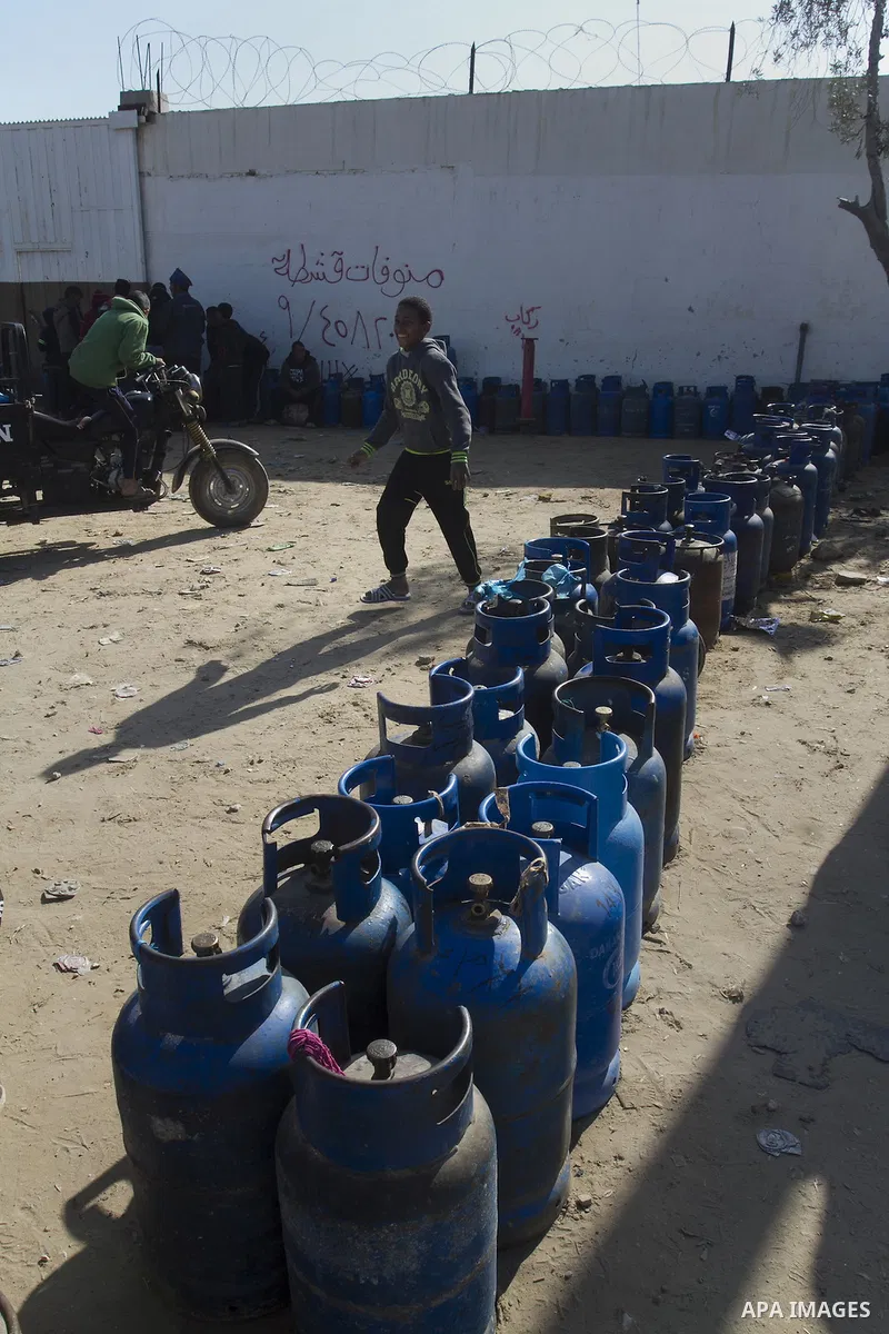 Palestinians wait to fill a cooking gas canister at a station in Rafah in southern Gaza Strip on January 14, 2016. Gas used for heating and cooking in Gaza is in short supply because of rationing. The power shortage stem...