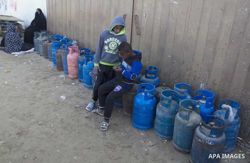 Palestinians wait to fill a cooking gas canister at a station in Rafah in southern Gaza Strip on January 14, 2016. Gas used for heating and cooking in Gaza is in short supply because of rationing. The power shortage stem...