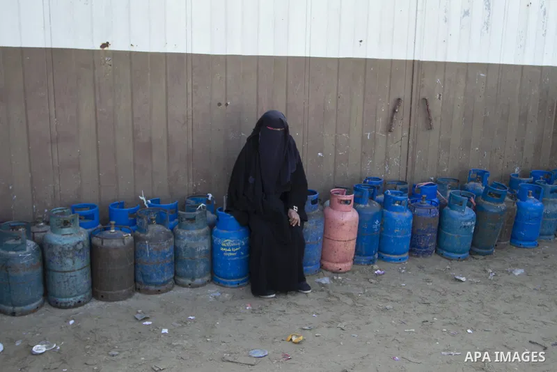 A Palestinian woman waits to fill a cooking gas canister at a station in Rafah in southern Gaza Strip on January 14, 2016. Gas used for heating and cooking in Gaza is in short supply because of rationing. The power short...
