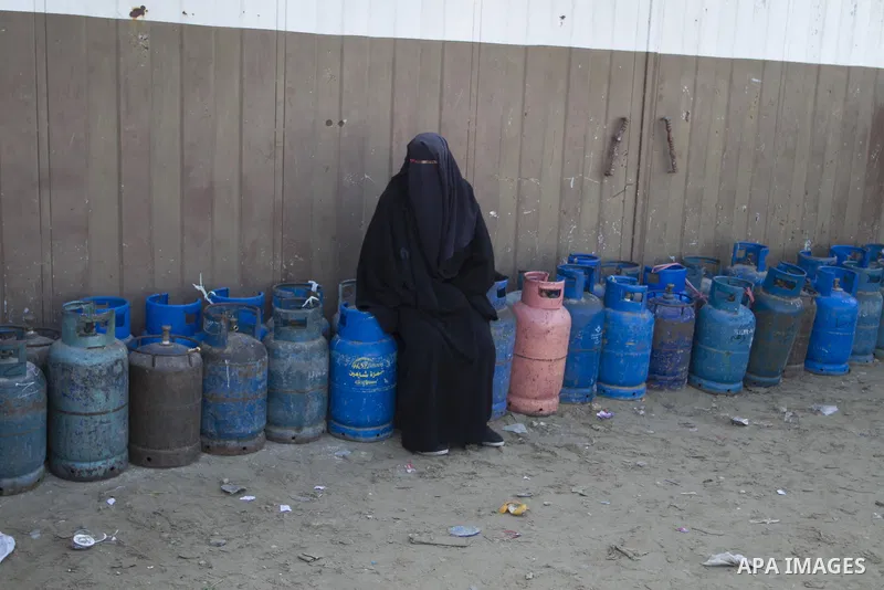A Palestinian woman waits to fill a cooking gas canister at a station in Rafah in southern Gaza Strip on January 14, 2016. Gas used for heating and cooking in Gaza is in short supply because of rationing. The power short...