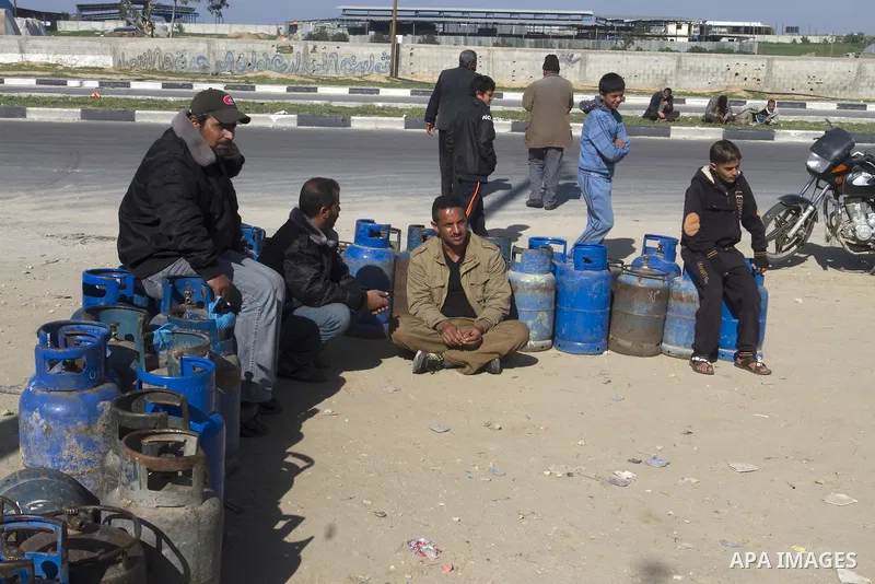 Palestinians wait to fill a cooking gas canister at a station in Rafah in southern Gaza Strip on January 14, 2016. Gas used for heating and cooking in Gaza is in short supply because of rationing. The power shortage stem...