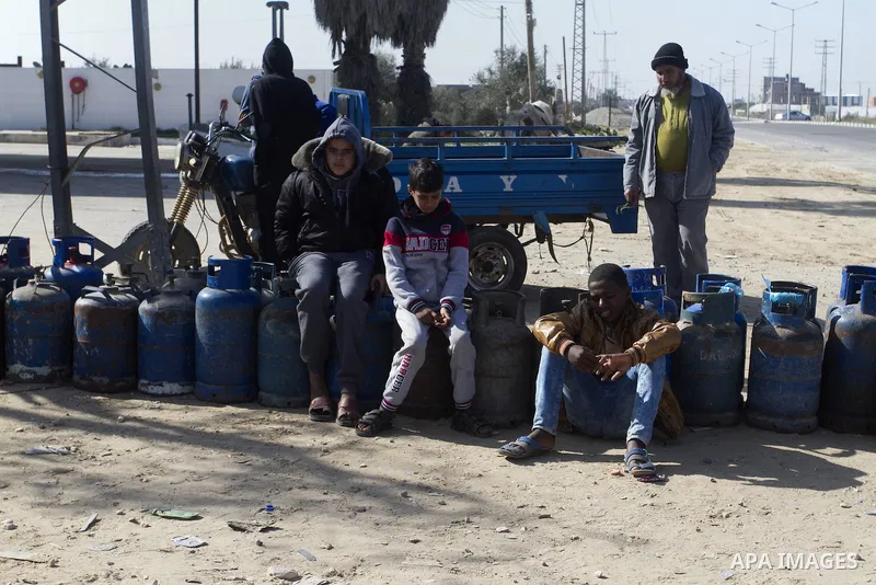 Palestinians wait to fill a cooking gas canister at a station in Rafah in southern Gaza Strip on January 14, 2016. Gas used for heating and cooking in Gaza is in short supply because of rationing. The power shortage stem...