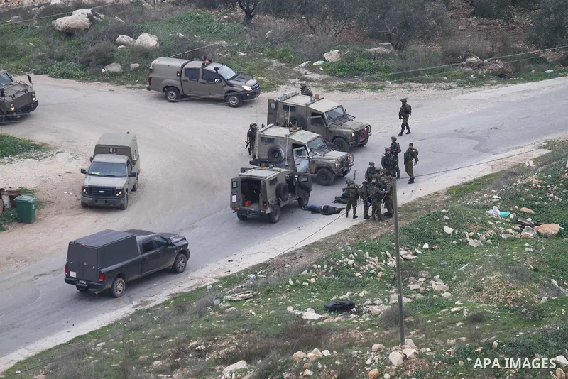 Israeli security forces gather around the body of a Palestinian man who was shot dead following a reported stabbing attack in the village of Assira al-Shamaliya near Nablus, in the occupied West Bank, on January 14, 2016...