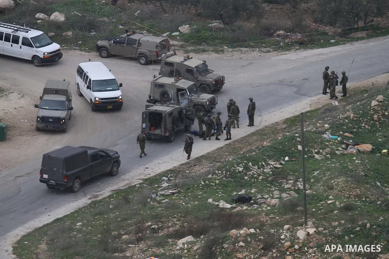 Israeli security forces gather around the body of a Palestinian man who was shot dead following a reported stabbing attack in the village of Assira al-Shamaliya near Nablus, in the occupied West Bank, on January 14, 2016...