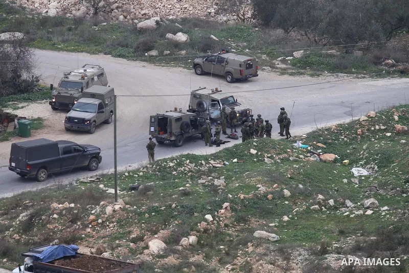 Israeli security forces gather around the body of a Palestinian man who was shot dead following a reported stabbing attack in the village of Assira al-Shamaliya near Nablus, in the occupied West Bank, on January 14, 2016...